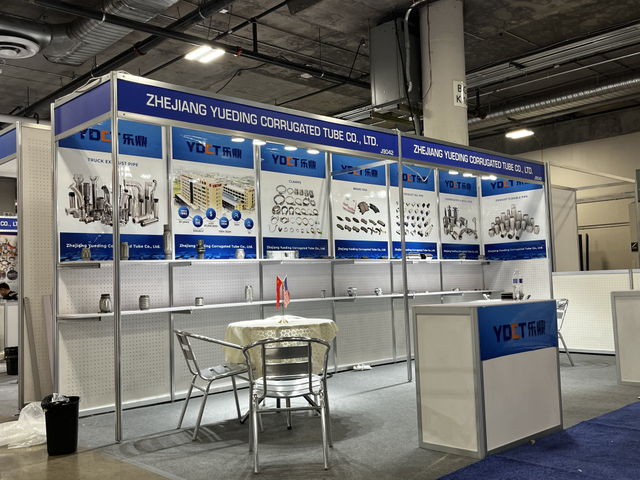 Booth da empresa exibindo grampos de escape e tubos flexíveis na feira do setor